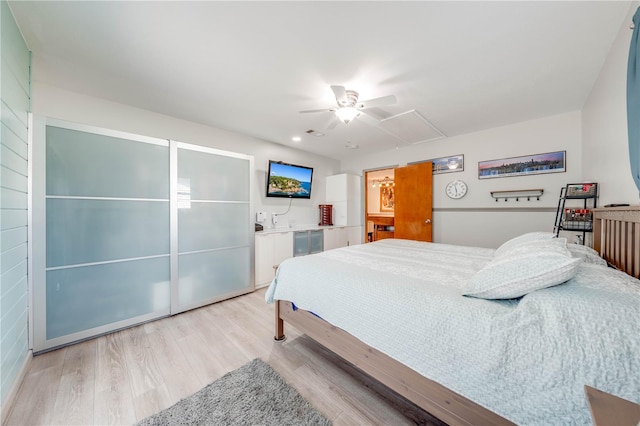 bedroom featuring attic access, a ceiling fan, light wood-type flooring, and visible vents