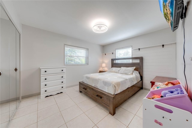 bedroom with light tile patterned floors and a closet