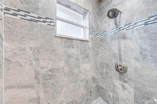 interior details featuring tiled shower