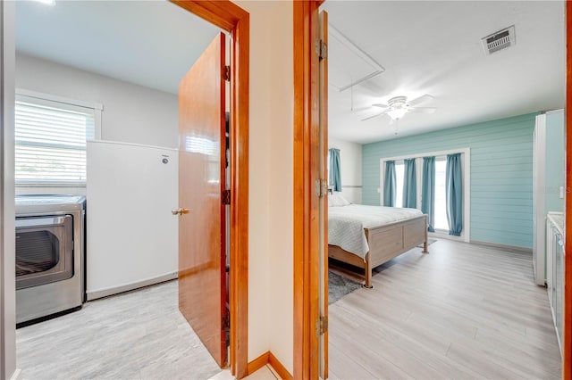 hallway featuring visible vents, washer and dryer, attic access, and wood finished floors