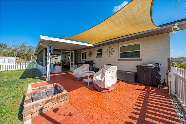 view of patio with grilling area, fence, and a fire pit