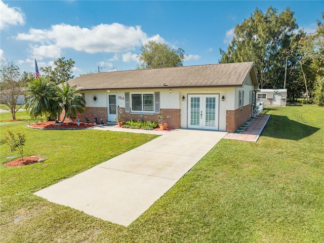 single story home featuring brick siding, stucco siding, french doors, and a front lawn