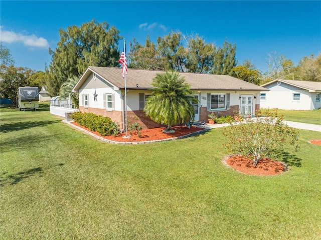 single story home featuring a front lawn, brick siding, and central AC