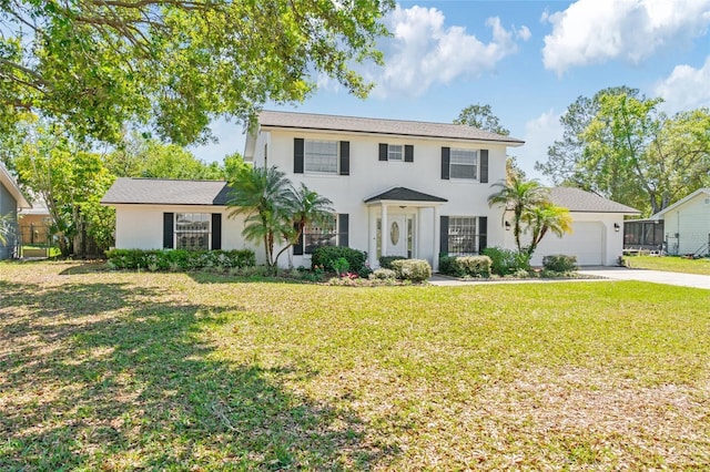 colonial-style house featuring a garage, stucco siding, concrete driveway, and a front yard