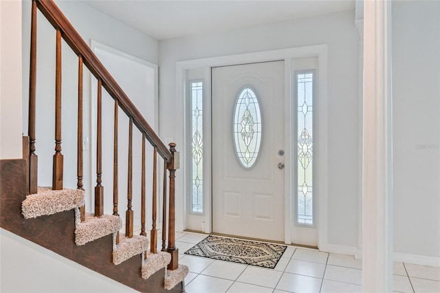 entrance foyer featuring tile patterned flooring, stairway, and a wealth of natural light