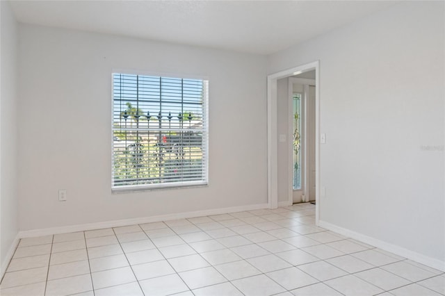 empty room featuring light tile patterned flooring and baseboards