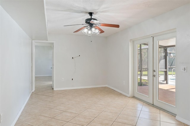 spare room featuring light tile patterned floors, french doors, baseboards, and ceiling fan