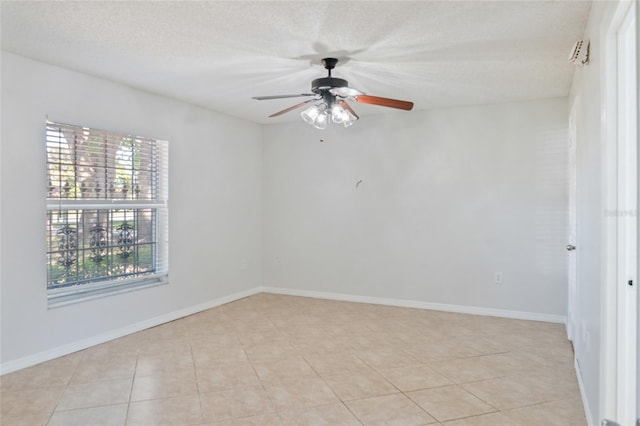 empty room with light tile patterned flooring, a ceiling fan, and baseboards