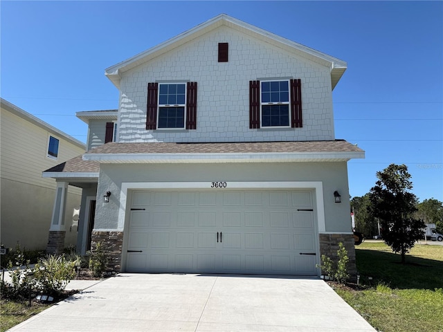 view of front of home featuring stone siding, driveway, a shingled roof, and a garage