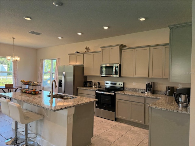 kitchen featuring visible vents, light tile patterned flooring, gray cabinets, a sink, and stainless steel appliances