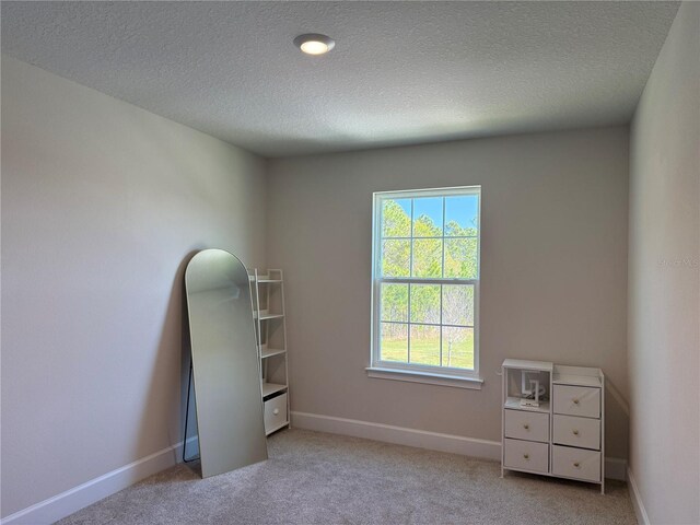 unfurnished bedroom featuring carpet flooring, baseboards, and a textured ceiling