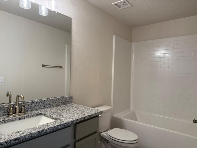 bathroom with vanity, visible vents, a textured ceiling, toilet, and shower / bathtub combination