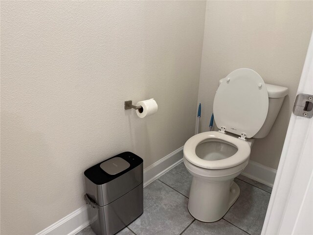 bathroom featuring tile patterned floors, toilet, and baseboards