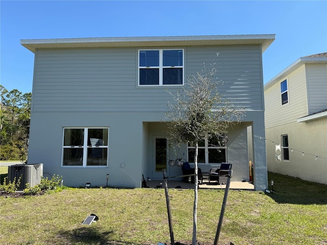 back of property featuring a patio, cooling unit, a lawn, and stucco siding