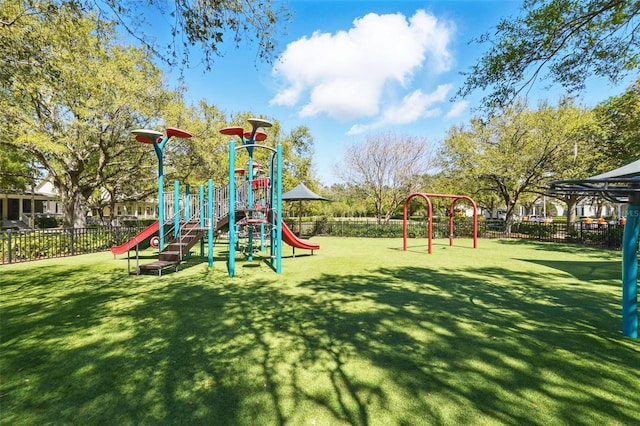 community play area featuring a lawn and fence