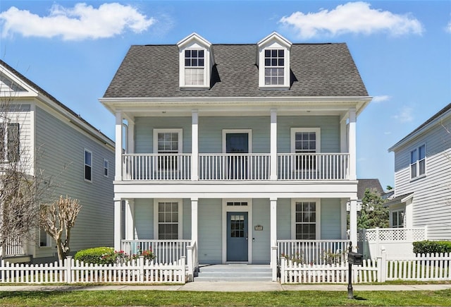 view of front of property with a fenced front yard, covered porch, and a shingled roof