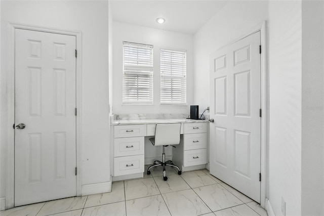 office space featuring built in desk and marble finish floor