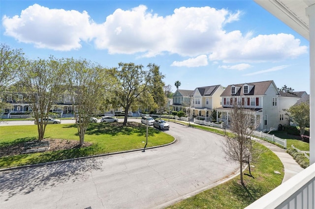 surrounding community featuring a yard, a residential view, and curved driveway