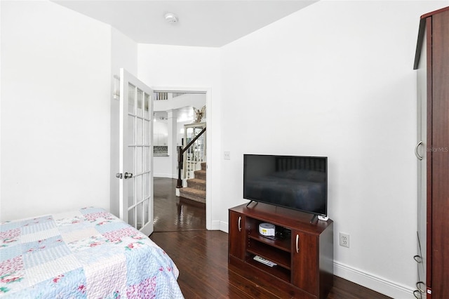 bedroom featuring baseboards and dark wood-style flooring