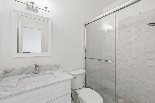 bathroom with toilet, a stall shower, and vanity