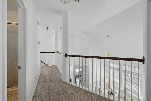 hall featuring an upstairs landing, carpet, and lofted ceiling