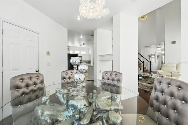 dining space with a chandelier, stairs, a wealth of natural light, and wood finished floors