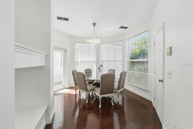 dining space with visible vents, wood finished floors, baseboards, and a chandelier