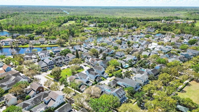 aerial view with a forest view, a water view, and a residential view