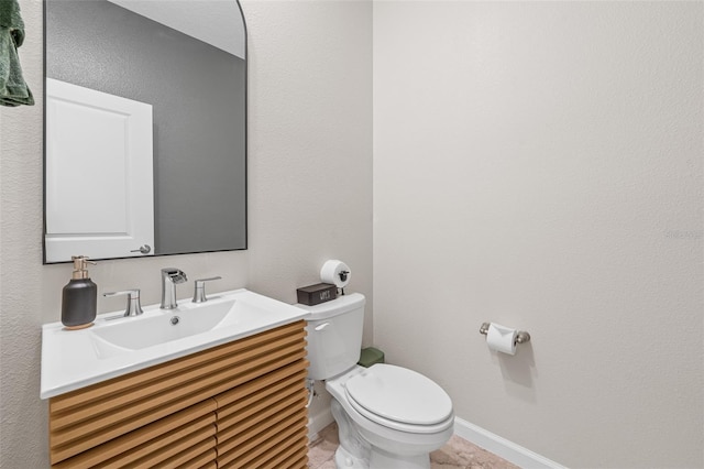 bathroom featuring vanity, toilet, and baseboards