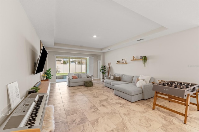 living room with visible vents and a raised ceiling