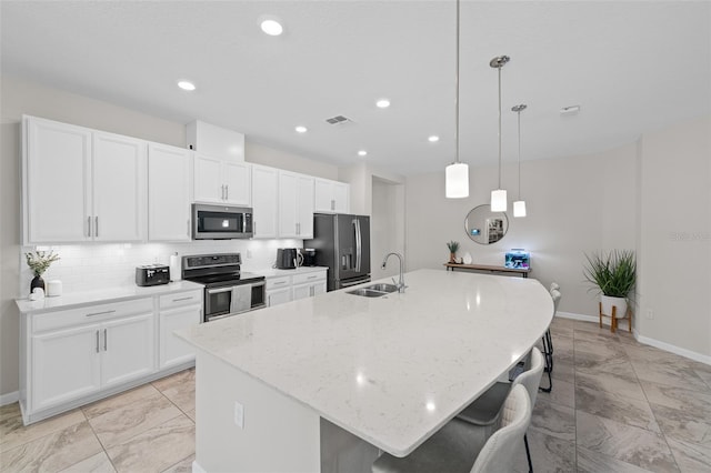 kitchen featuring visible vents, marble finish floor, a sink, stainless steel appliances, and a large island with sink