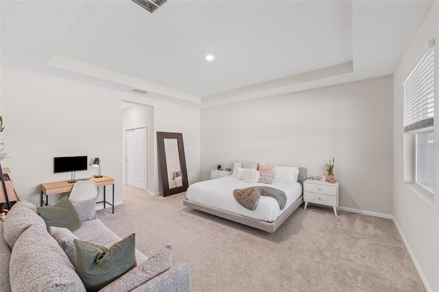 bedroom featuring a raised ceiling, baseboards, and carpet floors