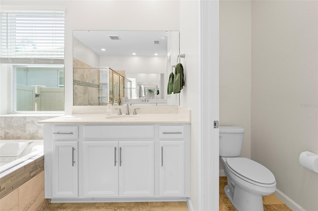 full bathroom with visible vents, a shower stall, toilet, a garden tub, and vanity