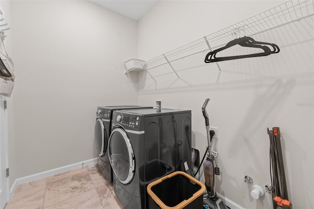 clothes washing area with laundry area, baseboards, and independent washer and dryer