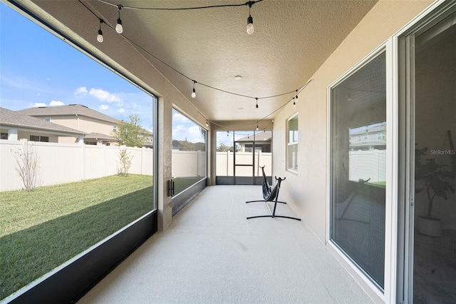 sunroom / solarium featuring track lighting