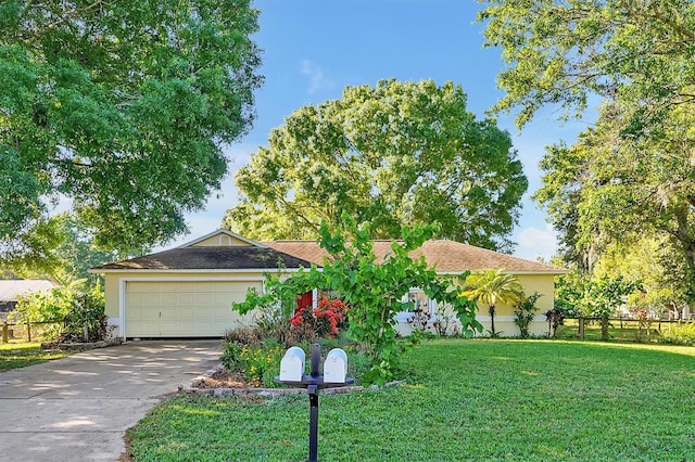 ranch-style house featuring a front yard, fence, driveway, stucco siding, and a garage