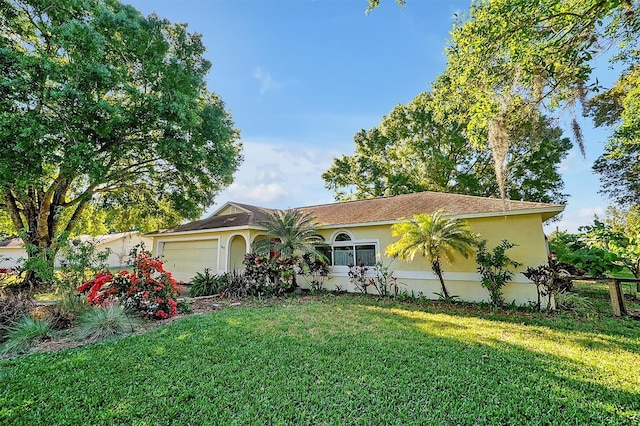 view of front facade featuring a front lawn, an attached garage, fence, and stucco siding