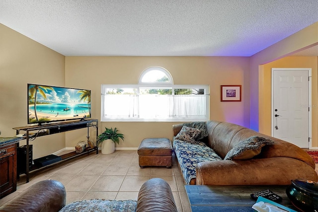 living room featuring light tile patterned floors, baseboards, and a textured ceiling