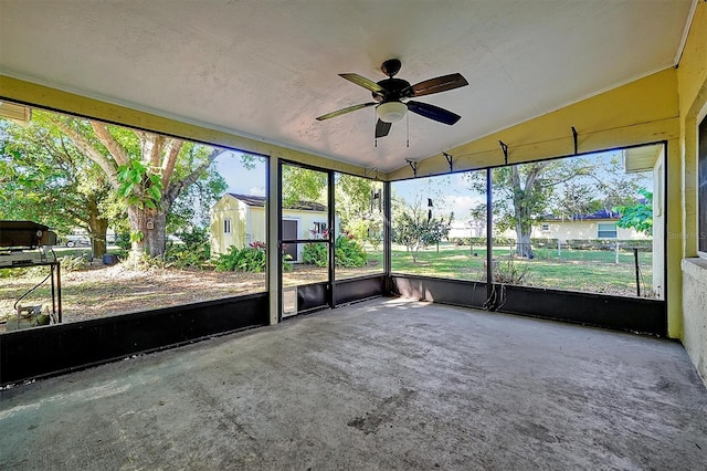 unfurnished sunroom with a wealth of natural light, lofted ceiling, and ceiling fan