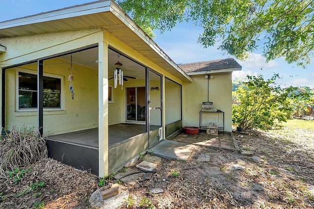 rear view of property with stucco siding, a patio, and ceiling fan