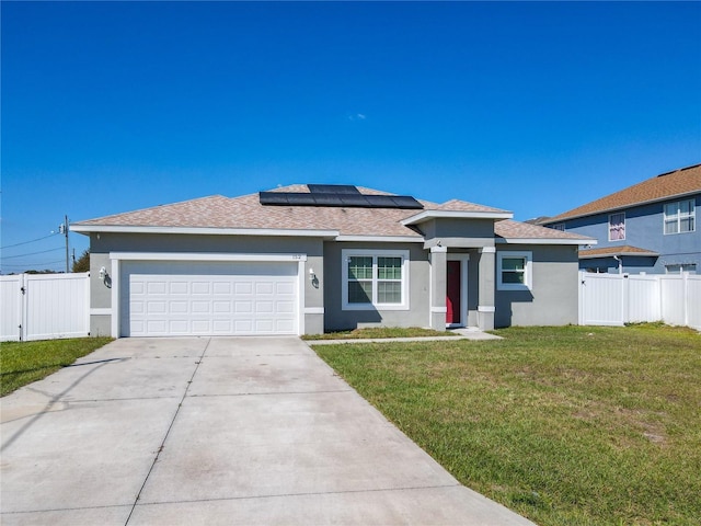 view of front of home with stucco siding, an attached garage, a front yard, and fence