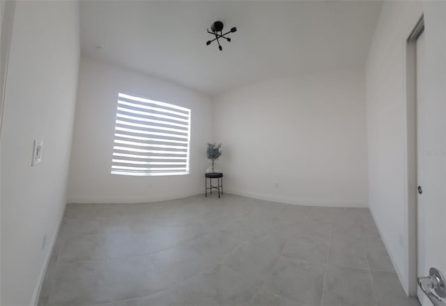 unfurnished room with baseboards