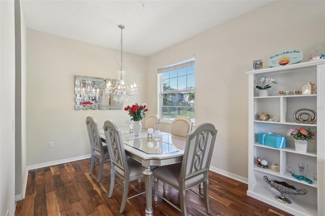 dining area with baseboards, an inviting chandelier, and wood finished floors