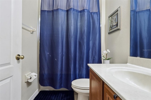 full bath featuring a shower with curtain, toilet, and vanity