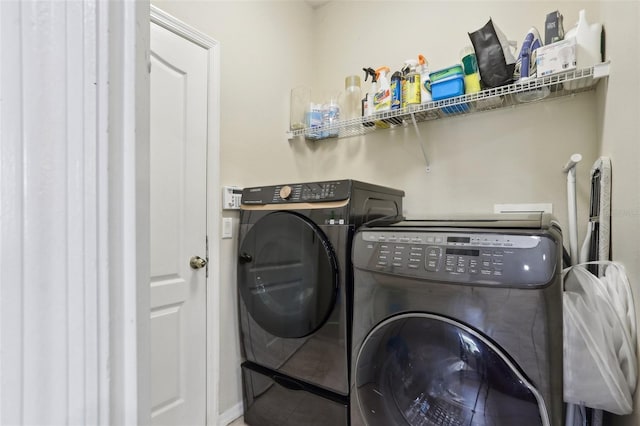 clothes washing area featuring tile patterned floors, laundry area, and washer and dryer