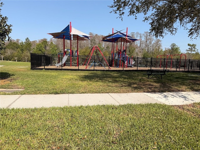 community playground featuring a lawn and fence