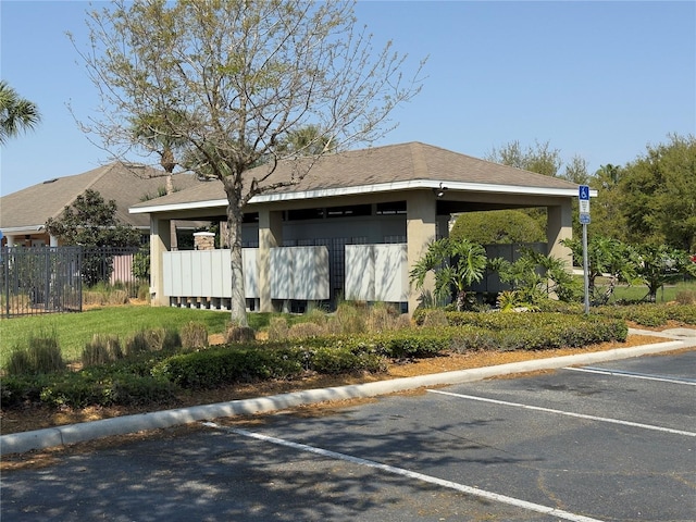 exterior space with uncovered parking, stucco siding, and fence