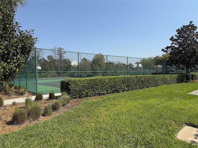 view of sport court featuring a yard, community basketball court, and fence