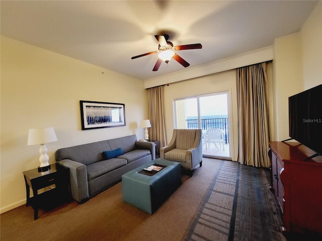 living room with dark colored carpet and a ceiling fan