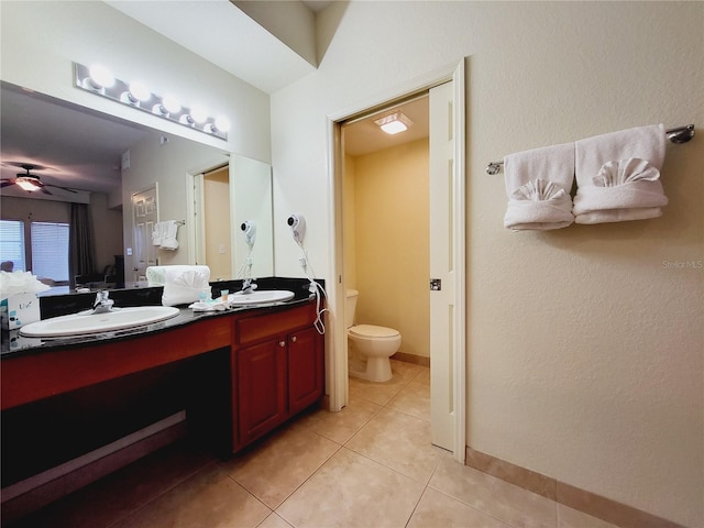 full bath with tile patterned floors, toilet, a sink, double vanity, and ceiling fan